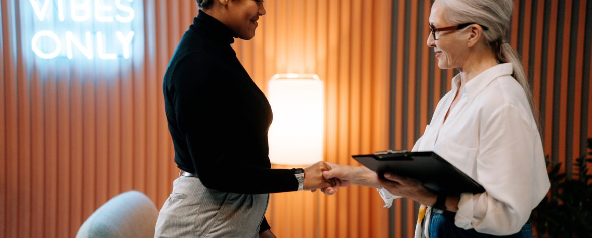 man in black long sleeve shirt and gray pants holding black tablet computer